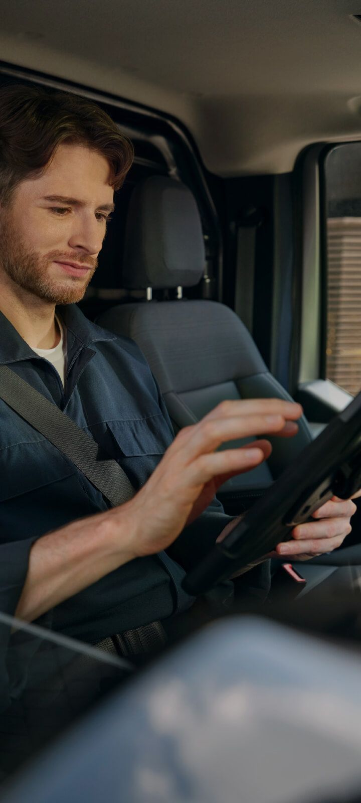 Mann, der mit dem Touchscreen eines Infotainment-Systems in einem Fahrzeug interagiert